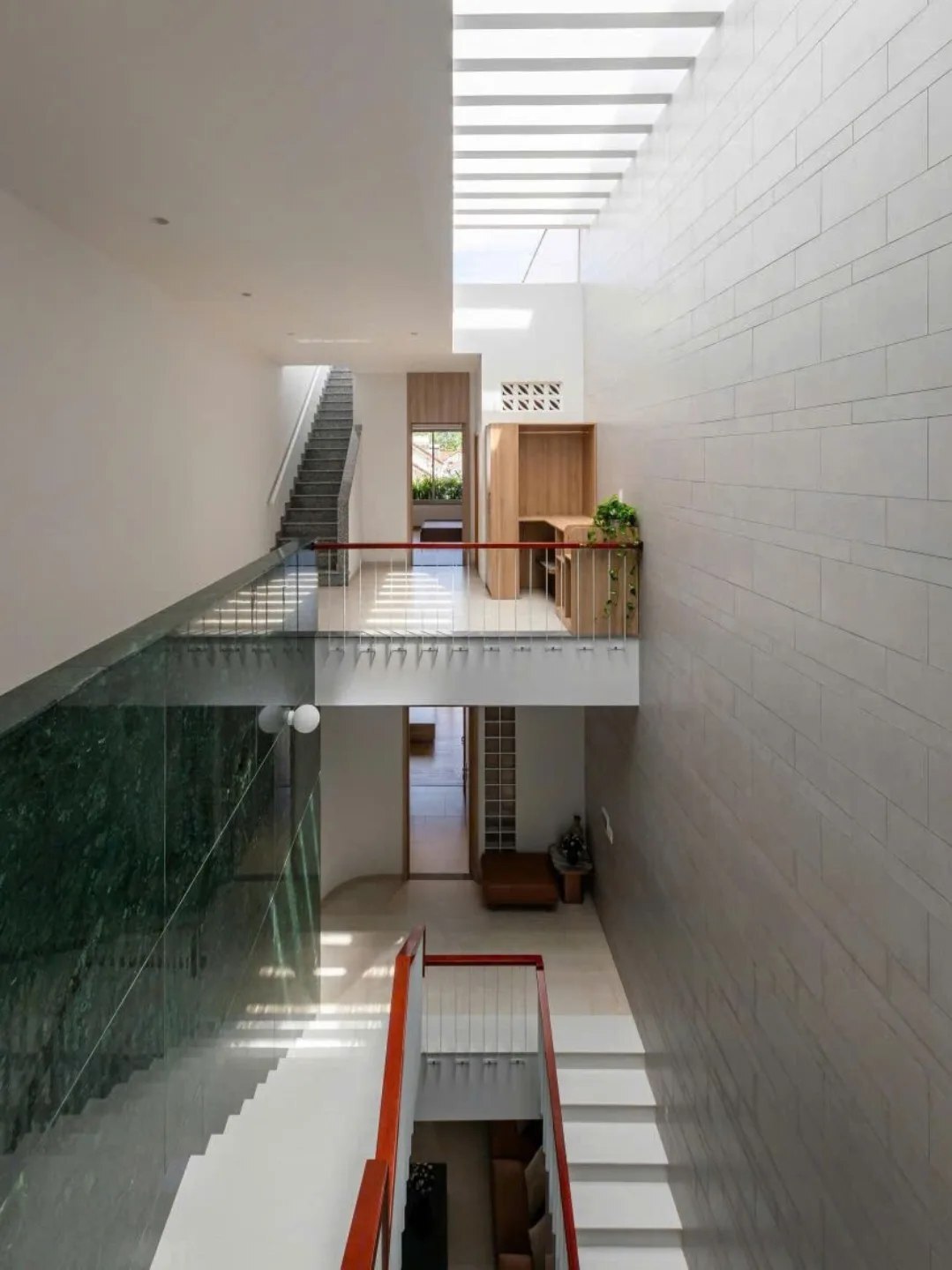 نمای خارجی و داخلی خانه چهار طبقه «شهر غربی» (Casa Cidade do Oeste) در ویتنام با مساحت ۹۰ متر مربع، که طراحی آن شامل نمای ساده، لایه‌های انبوه گیاهی برای حفظ حریم خصوصی، و فضاهای داخلی پلان باز با نورگیر مرکزی برای ایجاد محیطی آرام و روشن است.
