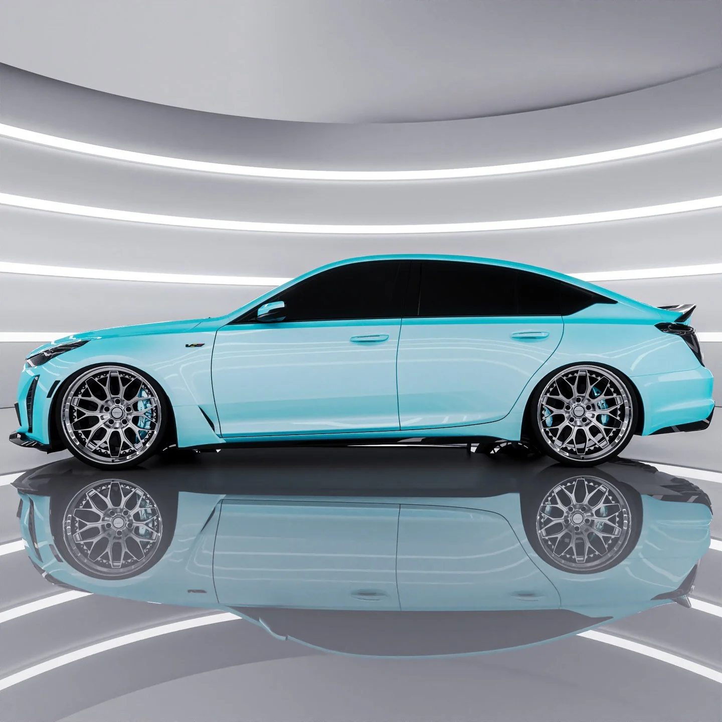 تصویری از سدان لوکس و پرفورمنس کادیلاک CT5-V بلک‌وینگ (Cadillac CT5-V Blackwing) با رنگ بدنه سفید متالیک (یخ قطبی) که بر روی رینگ‌های فورج سبک‌وزن با پوشش کرومی قرار دارد؛ این خودروی سوپرشارژر، پرچم‌دار سدان‌های اسپرت کادیلاک است.